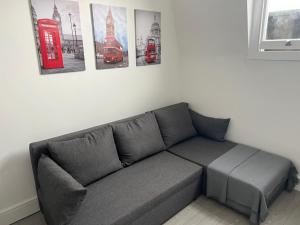 ein Sofa in einem Zimmer mit Bildern an der Wand in der Unterkunft 2 Bed Apartment in Central London on 3rd floor - Newly refurbished - No lift in London