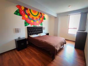 - une chambre avec un lit orné d'une peinture murale dans l'établissement Magic Packer Hostel, à Cusco
