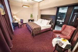 ein Hotelzimmer mit einem Bett und einem Stuhl in der Unterkunft Hotel Esprit in Prag