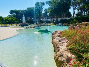 a pool of water with a light house and a lighthouse at EL DELFÍN VERDE RESORTS - Platja d'Aro in Platja d'Aro