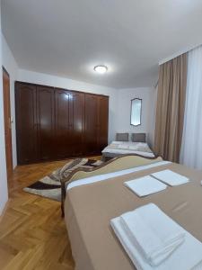 a hotel room with two beds and wooden cabinets at Jana apartments 2 in Tivat