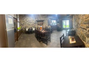 a restaurant with tables and chairs and a brick wall at Albergue San Anton in Melide