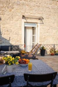 a table with a bowl of fruit and a glass of orange juice at Apartments Gabrieri in Dubrovnik