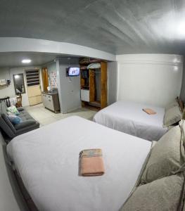 a room with two beds and a living room at Hospedagem Recanto dos Viajantes in Bom Jardim da Serra