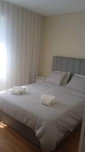 a white bed with two towels on top of it at Lisbon Breezy Haven 2Bedroom Oasis in Lisbon