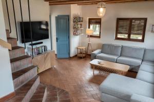 Una sala de estar con un sofá y un televisor. en Flateli Casa Indiana, en Bordils