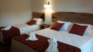 Dos camas en una habitación de hotel con toallas. en Kelta Hotel Puerto Iguazú CENTRO en Puerto Iguazú