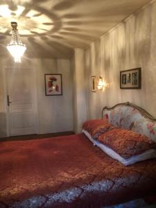 a bedroom with a bed and a chandelier at Le Calipel in Saint-Vigor-des-Monts