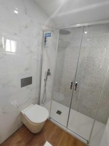 a white bathroom with a toilet and a shower at Lisbon Breezy Haven 2Bedroom Oasis in Lisbon