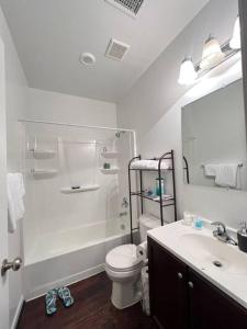 La salle de bains blanche est pourvue de toilettes et d'un lavabo. dans l'établissement Classic 6Bed,3.5Bath at the heart of Lanham next door to DC. Maryland, à Lanham
