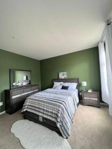 - une chambre avec des murs verts, un lit et un miroir dans l'établissement Classic 6Bed,3.5Bath at the heart of Lanham next door to DC. Maryland, à Lanham