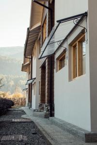 Un edificio blanco con ventanas a una calle. en Mebruck Lago Puelo, en Lago Puelo
