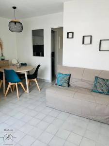 un soggiorno con divano e tavolo di L'OSLO Superbe T2 - à 3 min de la mer - clim / wifi - 1 Chambre a La Grande-Motte