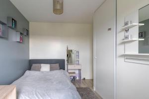 ein kleines Schlafzimmer mit einem Bett und einem Spiegel in der Unterkunft Beautiful and Spacious Parisian House in Cormeilles-en-Parisis