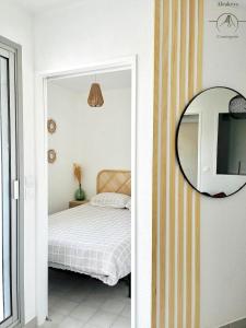 una camera con letto e specchio di L'OSLO Superbe T2 - à 3 min de la mer - clim / wifi - 1 Chambre a La Grande-Motte
