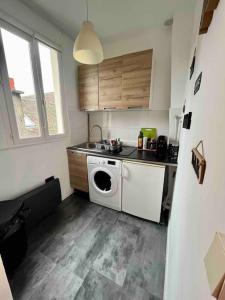 une cuisine avec une machine à laver et un évier dans l'établissement Peaceful Stay Near Insead and Castle, à Fontainebleau 10 autres photos