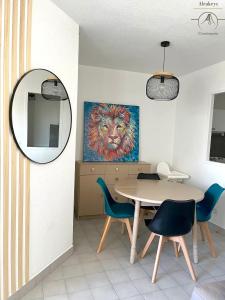 uma sala de jantar com uma mesa e uma pintura de um leão em L'OSLO Superbe T2 - à 3 min de la mer - clim / wifi - 1 Chambre em La Grande-Motte