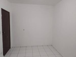 an empty room with a door and a white tile floor at Casa com churrasqueira para Lollapalooza in Sao Paulo