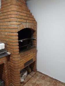 um forno de tijolo num quarto com uma parede em Casa com churrasqueira para Lollapalooza em São Paulo