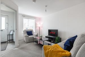 a living room with a couch and a tv at NEW Luton 3 Bedroom house, Contractors & families, Sleeps 7 with Free Parking & WIFI in Luton
