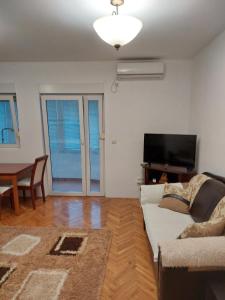 a living room with a couch and a television at Jana apartments 2 in Tivat