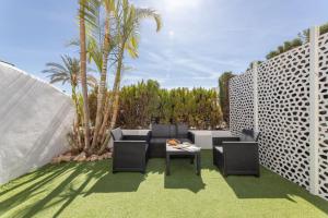 un patio con 2 sillas y una mesa en Casa Jardines del Sol J5, en Marbella