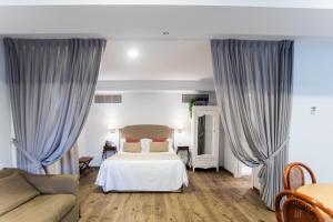 1 dormitorio con 1 cama y 1 sofá en Le Petit Apartamentos en Santander