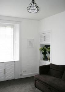 a living room with a couch and two windows at Galashiels, Scottish Borders, One Double Bed in Galashiels