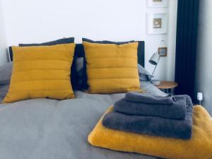 a bed with blue and yellow pillows and a bed with at Galashiels, Scottish Borders, One Double Bed in Galashiels