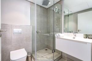 een badkamer met douche, toilet en wastafel bij Cape Town Bree Street 27th Floor Studio Apt Views in Kaapstad +17 foto's