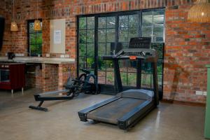 a gym with two exercise bikes in a brick wall at Kamps Apartment - Foxdale Forest in Lusaka