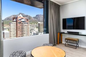 een kamer met een groot raam met uitzicht op een stad bij Cape Town Bree Street 27th Floor Studio Apt Views in Kaapstad