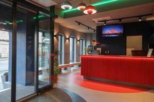 a restaurant with a red counter and a tv on the wall at acama Hotel & Hostel Kreuzberg in Berlin