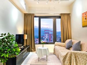 a living room with a couch and a large window at Tropicana 218 Macalister by NGN in George Town
