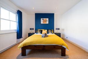 a bedroom with a yellow bed with blue walls at 2 Bed Central Tunbridge Wells in Royal Tunbridge Wells