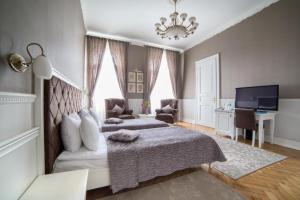 a bedroom with a bed and a couch and a tv at Modern Art Hotel in Lviv