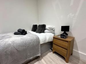 a bedroom with a bed and a wooden night stand at Hotel Studio Escape in Kent in Kent