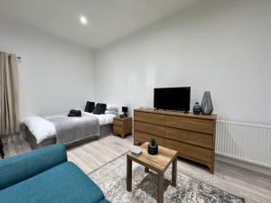 a living room with a couch and a tv at Hotel Studio Escape in Kent in Kent