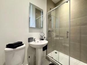 y baño con aseo, lavabo y ducha. en Hotel Studio Escape in Kent en Kent