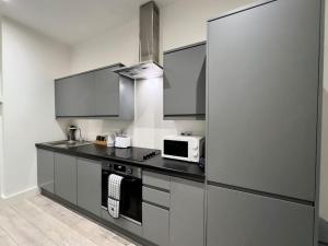 a kitchen with black counters and a microwave at Hotel Studio Escape in Kent in Kent
