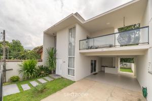 een groot wit huis met een balkon bij Casa de 2 pisos a 110m da praia em Piçarras SAP260 in Piçarras