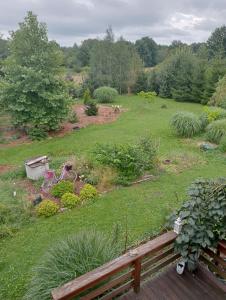 een uitzicht op een tuin met een houten bank bij Drewniana chatka in Budy Stare