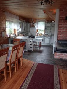 een keuken met een tafel en stoelen in een kamer bij Drewniana chatka in Budy Stare