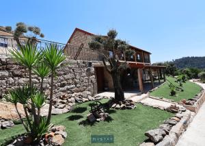 una casa con un patio con árboles y rocas en MyStay - Casa do Vale JC, en Vila Nune