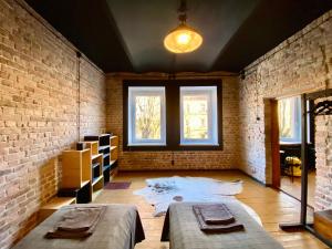 um quarto com duas camas e uma parede de tijolos em Zielona Park Industrial Studio em Dabrowa Górnicza