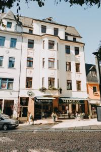 um grande edifício branco no lado de uma rua em City Pension em Reichenbach im Vogtland