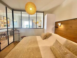um quarto com uma cama grande e um lustre em Gallia Park by Welcome to Cannes em Cannes