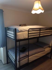 2 łóżka piętrowe w pokoju z lampką w obiekcie Connolly Private Guest House w Dublinie