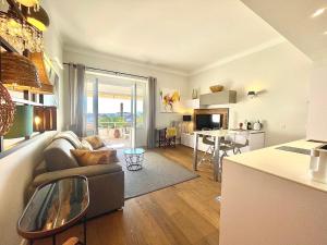 uma cozinha e sala de estar com um sofá e uma mesa em Gallia Park by Welcome to Cannes em Cannes