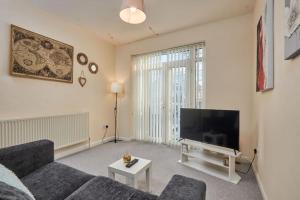 uma sala de estar com um sofá e uma televisão de ecrã plano em Comfy Home on Burton Road em Derby